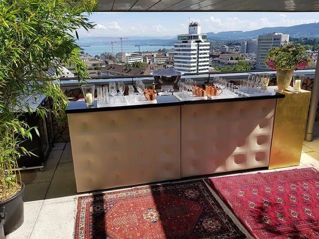 Luxury rooftop cocktail bar with tufted finish and city skyline for corporate networking events.