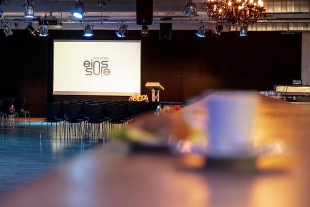 Industrial plenary space with coffee break setup for corporate events and business conferences.
