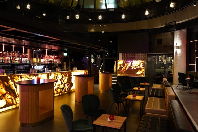 VIP lounge with back-lit bar for high-end networking and cocktail reception events.