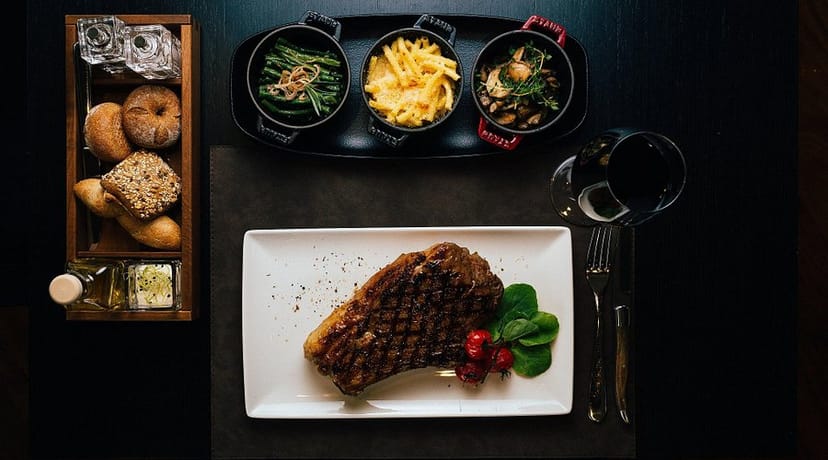Upscale steakhouse VIP dining with shared family-style sides for corporate events and galas.