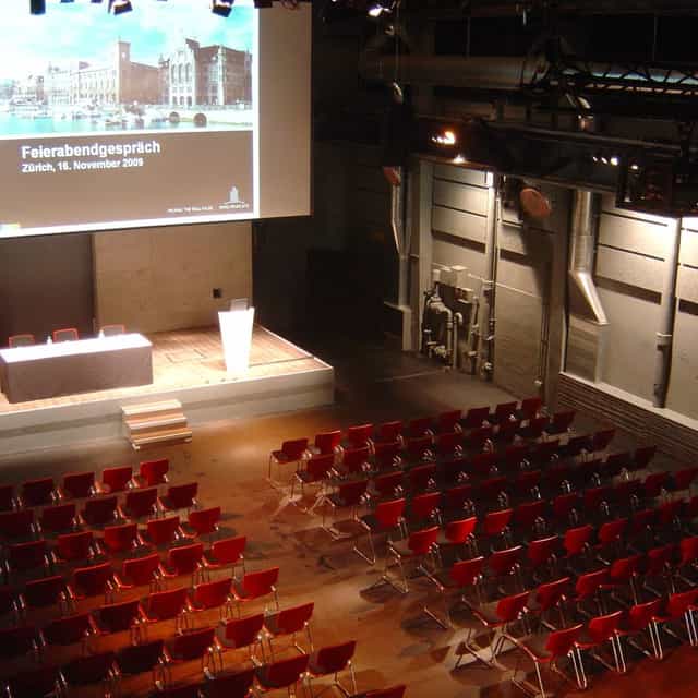 Härterei Club industrial venue with stage and theater seating for corporate events and conferences.