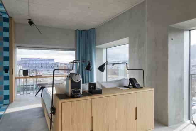 Modern hotel room with workspace and floor-to-ceiling windows for business travel.