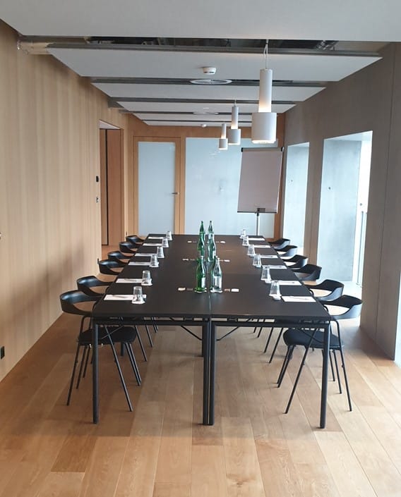 Minimalist boardroom with long table for business meetings and corporate strategy sessions.