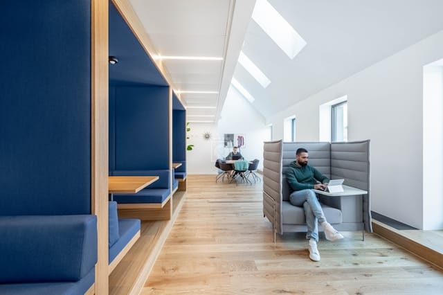 Modern hybrid coworking space with acoustic booths for focused work and professional meetings.