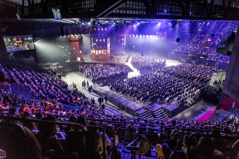 Hallenstadion Zürich main hall, large-scale plenary stage, corporate keynote, conference setup.
