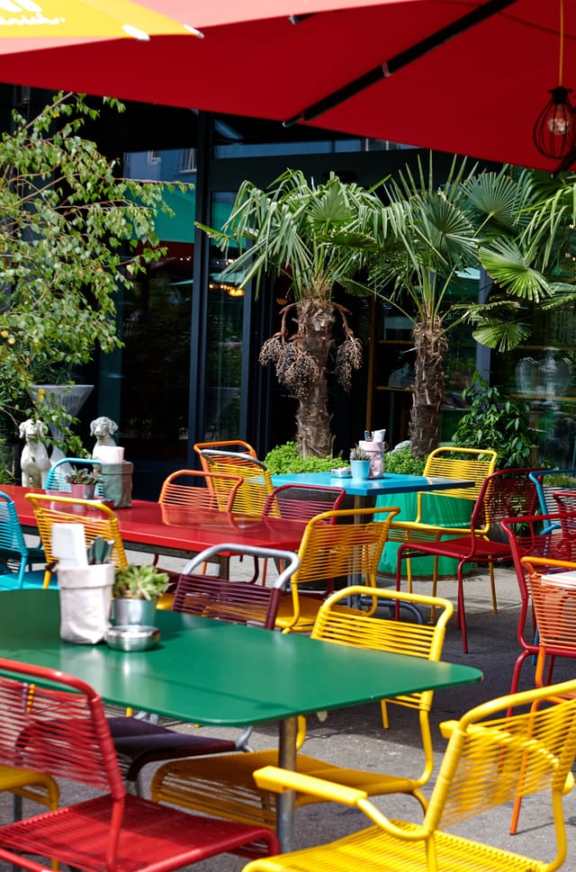 Vibrant outdoor networking event at 25hours Hotel Zurich with eclectic furniture.