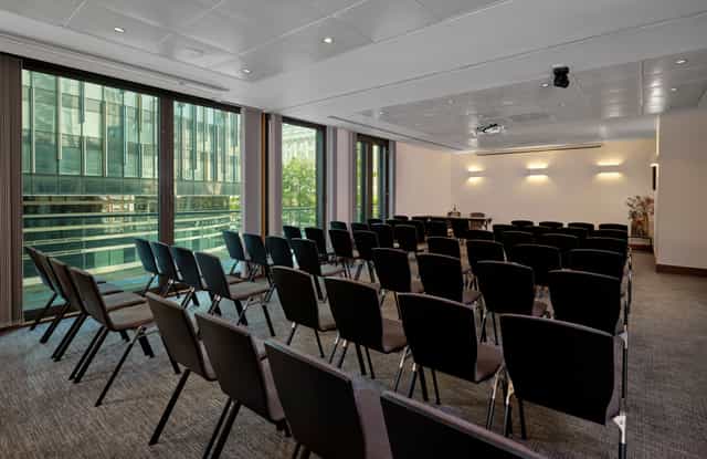 Putney and Westminster Suite: bright meeting room with black chairs for corporate events.