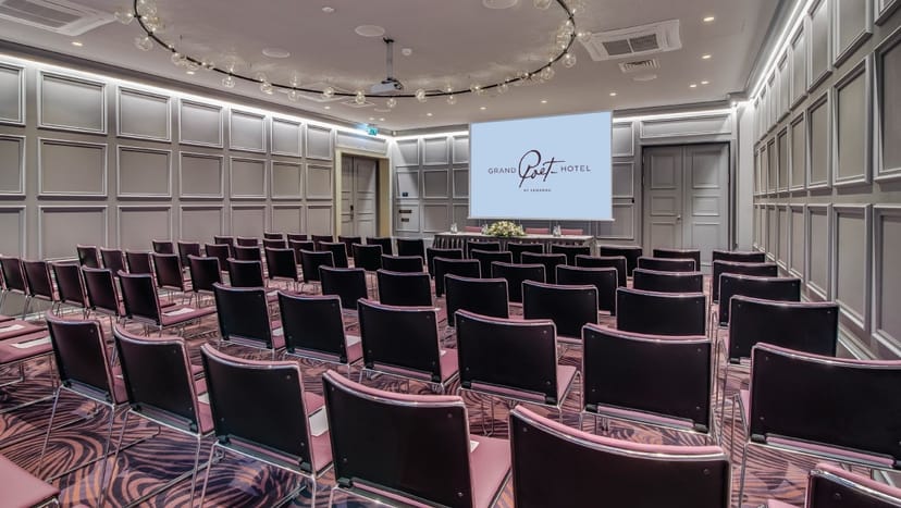 Theater-style meeting room at Grand Poet Hotel with wood paneling for executive seminars.
