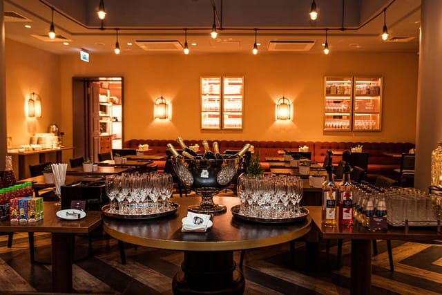 Cocktail reception at Grand Poet Hotel restaurant with central bar for networking events.