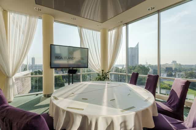 Modern boardroom with floor-to-ceiling windows at Riga Islande Hotel for executive meetings.