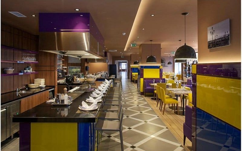 Modern restaurant networking event space with high-top chef counter at Mercure Hotel Riga Centre.