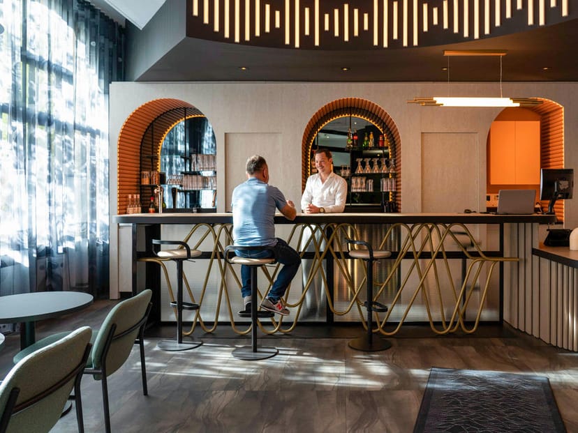 Modern Accor hotel restaurant with high-top seating for business networking and breakout meetings.