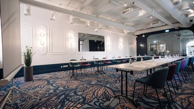 Modern Wellton Hotels boardroom with patterned carpet for corporate meetings and workshops.