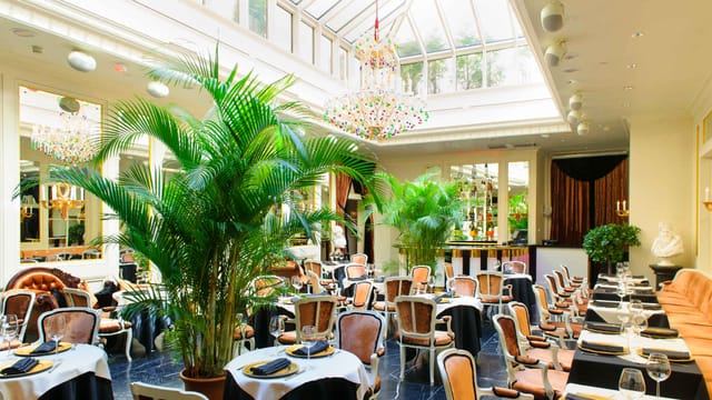 Upscale hotel atrium dining room for elegant banquet events and luxury corporate functions.