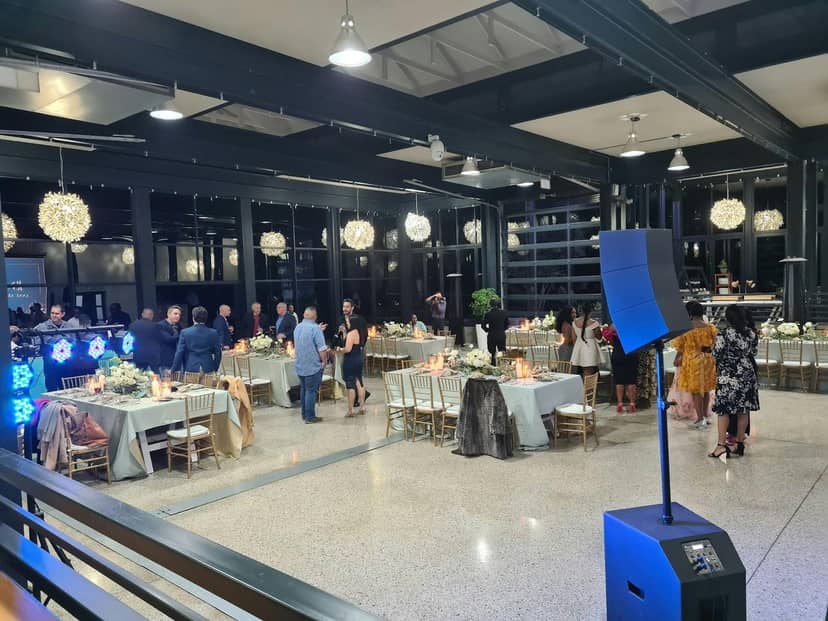 Modern industrial-chic event venue with round tables, perfect for formal banquets and weddings.