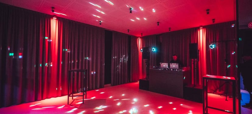 Pestalozzi Hall lounge with red ambient lighting for corporate evening events and social mixers.