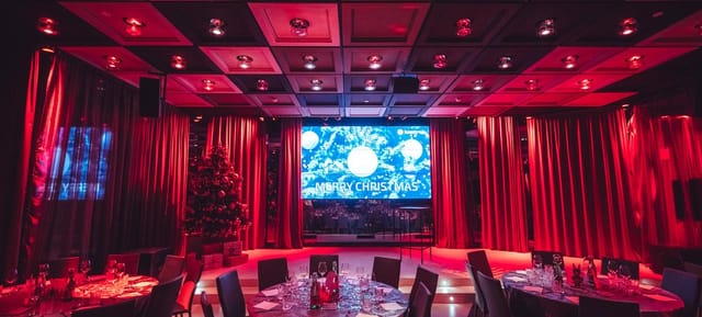 Pestalozzi Hall ballroom with red uplighting for corporate Christmas gala event.