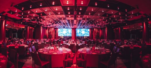 Pestalozzi Hall ballroom with red lighting for corporate gala and awards ceremony.