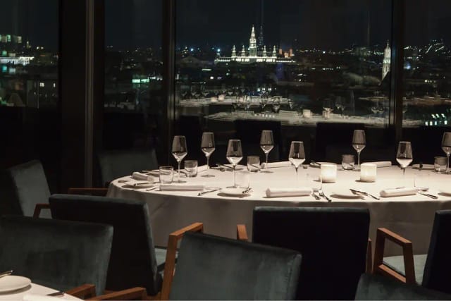 Elegant gala dinner at JUWEL featuring floor-to-ceiling windows for executive networking events.