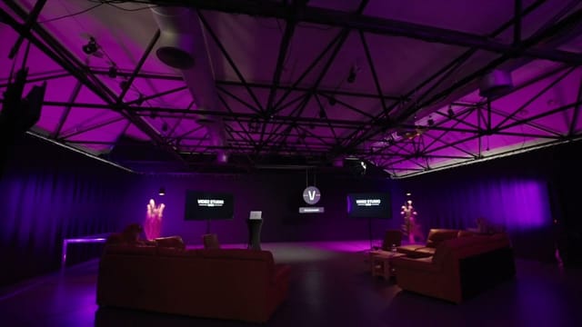 Industrial-chic HOIV studio with purple uplighting for hybrid events and professional productions.