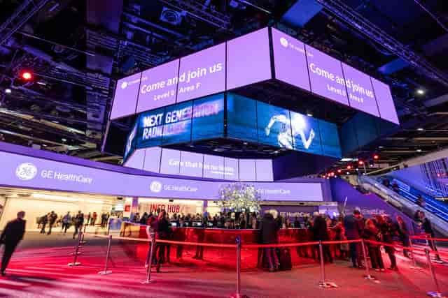 polySTAGE exhibition stand with overhead digital signage at an Austria Center Vienna trade show.