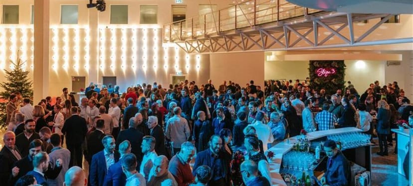 High-energy networking reception at Stage 3 event venue with architectural lighting.