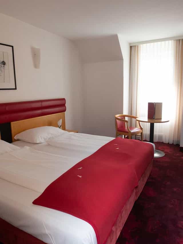 Standard hotel room with workspace for business travelers, neutral decor, and modern design.