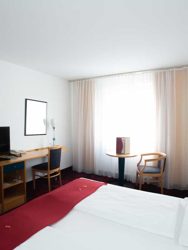 Hotel Boltzmann guest room with workspace, ideal for business travel and corporate conferences.