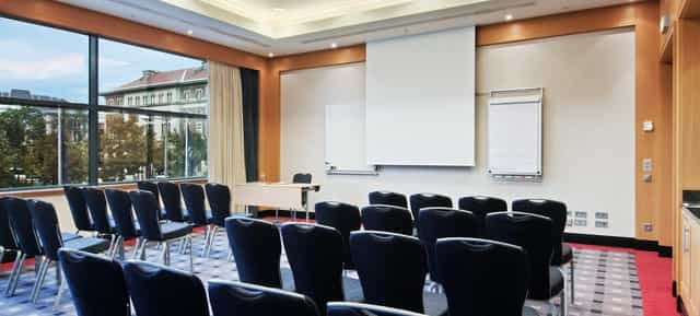 Theater-style banquet hall at Hilton Vienna Park with natural light for professional conferences.