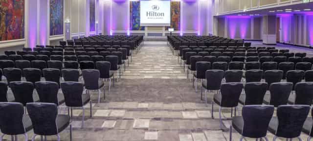 Hilton Vienna Park theater-style banquet hall for corporate plenary session and business conference.