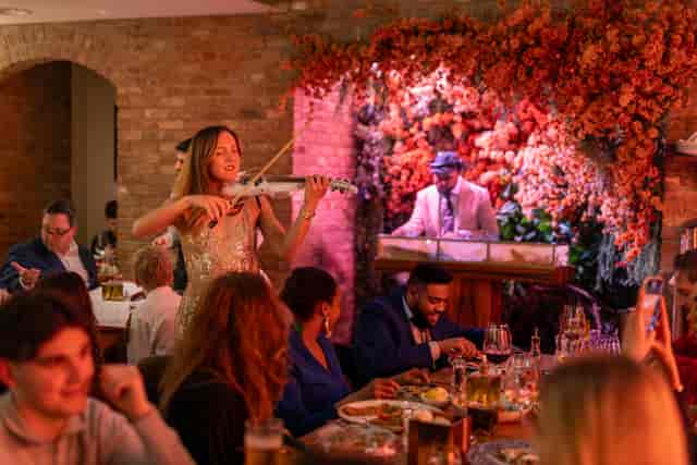 Bocconcino Mayfair experiential dining with roaming violinist for luxury private event hire.