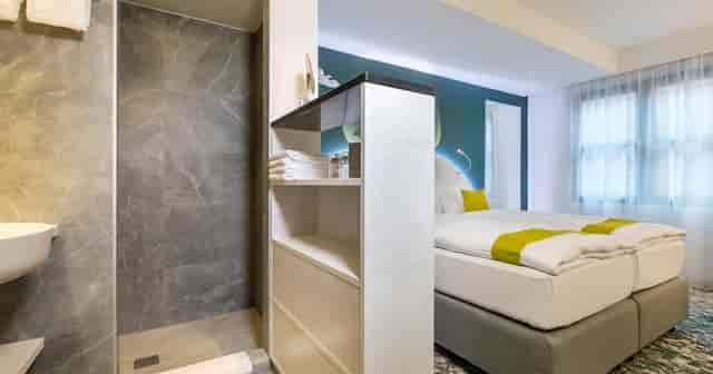 ARCOTEL Donauzentrum Wien open-concept hotel room for business travel and modern event accommodation.