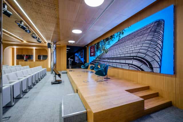 Modern auditorium with LED wall and tiered seating for corporate keynotes and executive meetings.