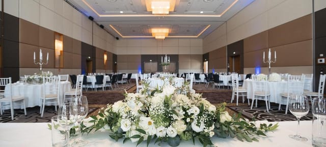 Hilton Vienna Waterfront ballroom with floral centerpieces for corporate events and wedding galas.
