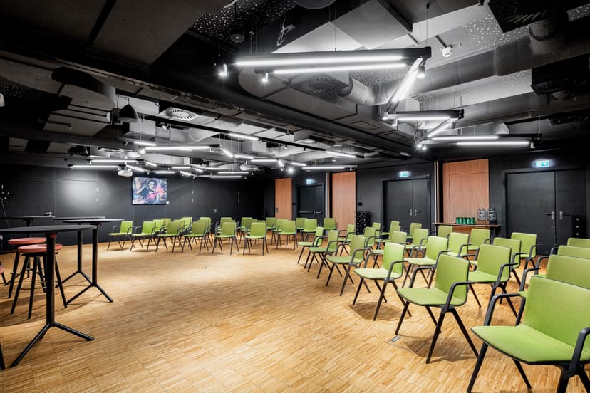 Industrial-chic conference room with theater seating for creative workshops and corporate events.