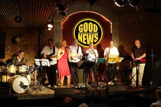 Corporate reception at CLUB 1019 featuring a live band and professional branded stage backdrop.
