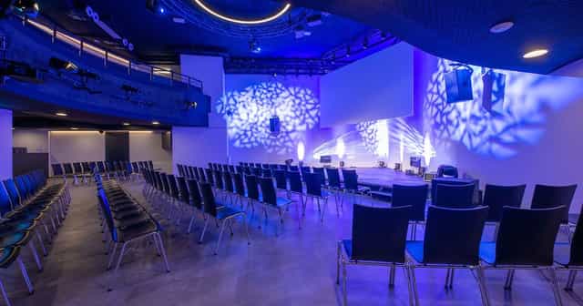 Modern corporate event space with theater seating for professional keynotes and product launches.