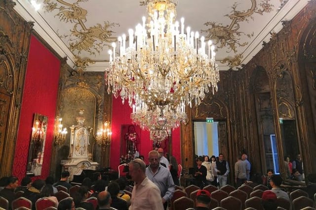 Red Salon event space with opulent chandelier for luxury gala and historic reception venue.