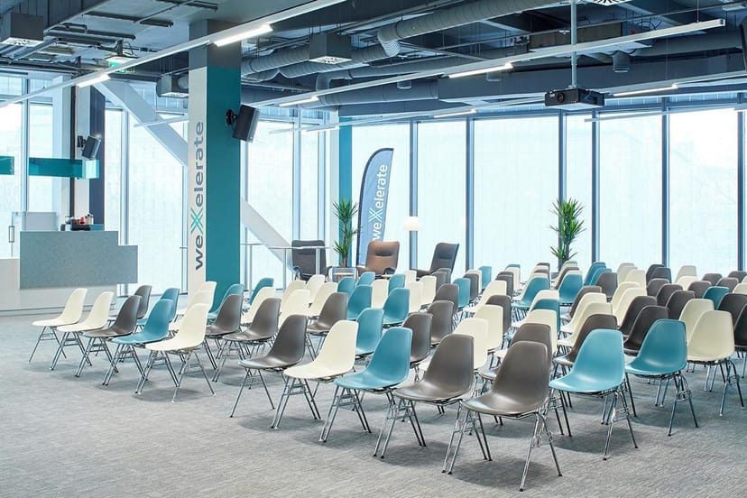 Modern weXelerate auditorium with theater seating for corporate presentations and conferences.