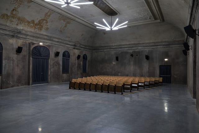 Industrial theater venue at REAKTOR featuring raw chic aesthetics for product launches and events.
