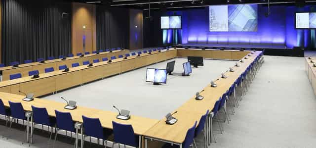U-shaped conference room with AV equipment for corporate meetings and board sessions.