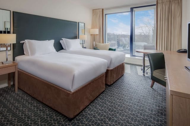 Modern Hilton Dublin Kilmainham twin guest room with workspace for business conferences.