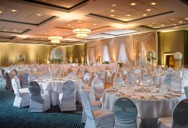 Ballroom event space with round tables and floral centerpieces for gala or wedding venue hire.