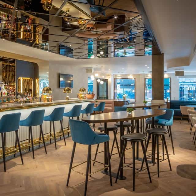 Upscale restaurant bar with high-top seating for networking events and cocktail receptions.