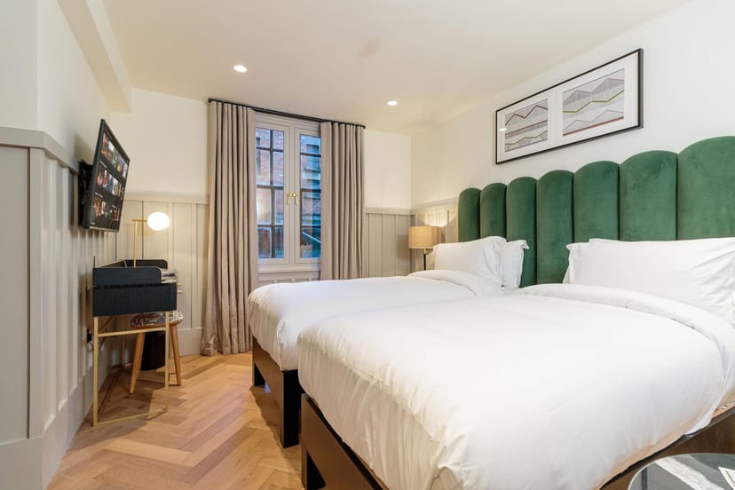 Modern twin hotel room at The Clarence, featuring workspace for corporate events and room blocks.