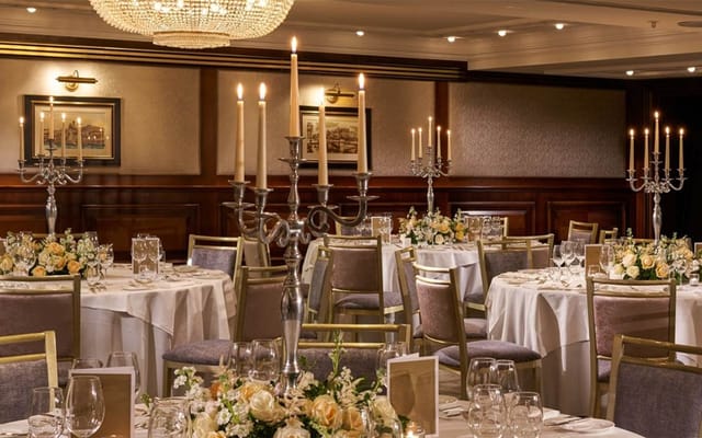 Elegant ballroom gala with silver candelabras and floral centerpieces for wedding or banquet.