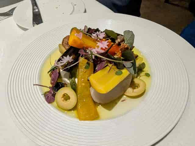 Gourmet plated appetizer with floral garnish for corporate gala or VIP dinner event.