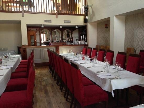 Banquet-style table with red chairs for corporate luncheon or rehearsal dinner event venue.