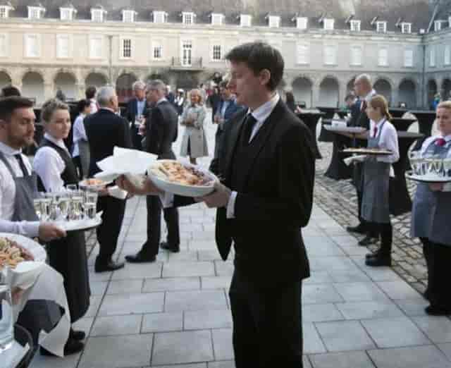 Professional catering staff at an outdoor cocktail reception, Exchange venue event service.