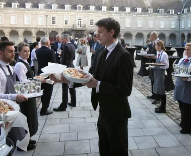 Professional catering staff at an outdoor cocktail reception, Exchange venue event service.
